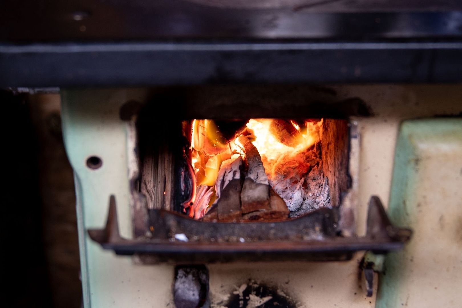 Brinnande ved i en kamin med synlig brännkammare och eldstad